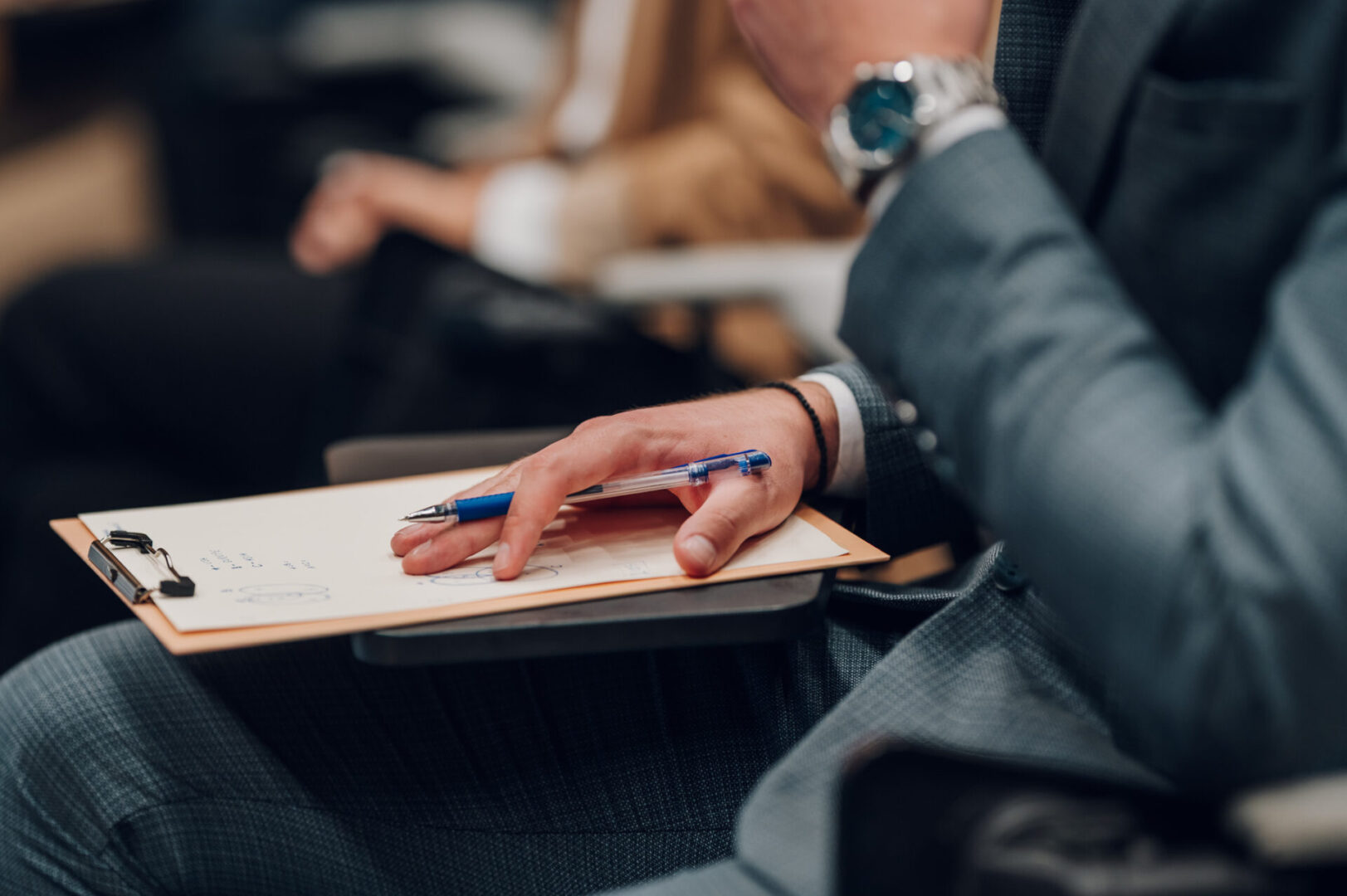 Person holding pen and clipboard